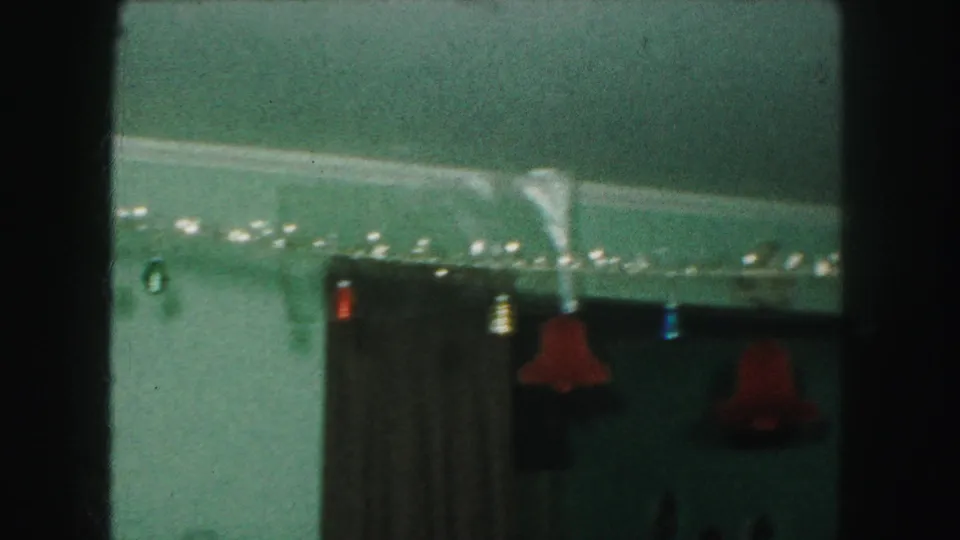 1959 Kansas City home interior showing Christmas garland, red hanging bells, curtains, and decorations near the ceiling.