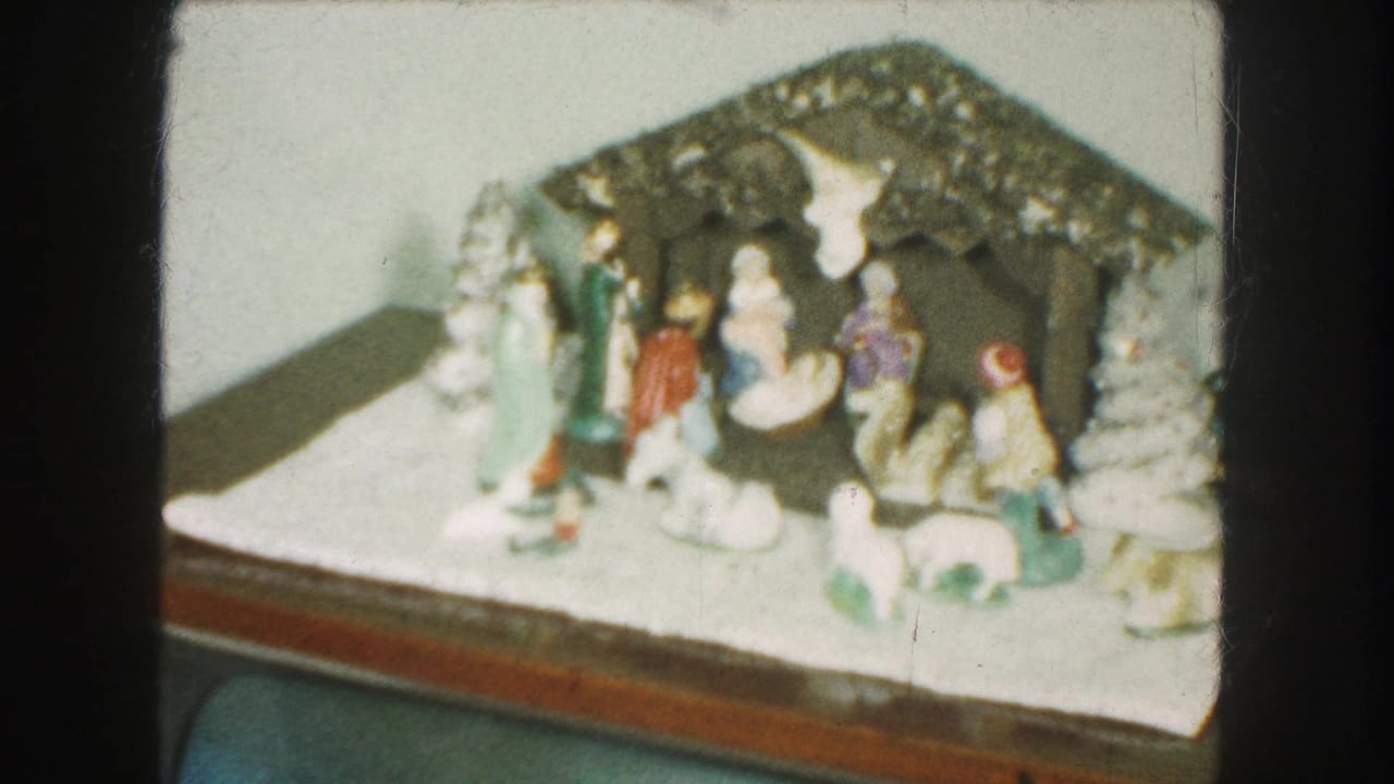 Soft 8mm view of a Kansas City Christmas nativity arrangement with ceramic figures, a stable roof, and white decorative trees.