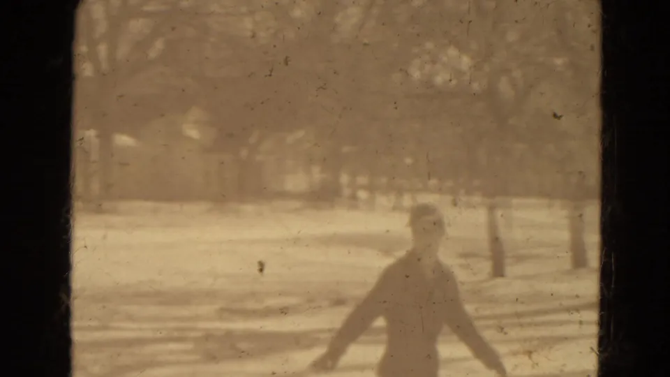 A bundled person moves near the bottom of the frame in snowy Lincoln, Nebraska footage, with the sleigh and winter landscape behind.