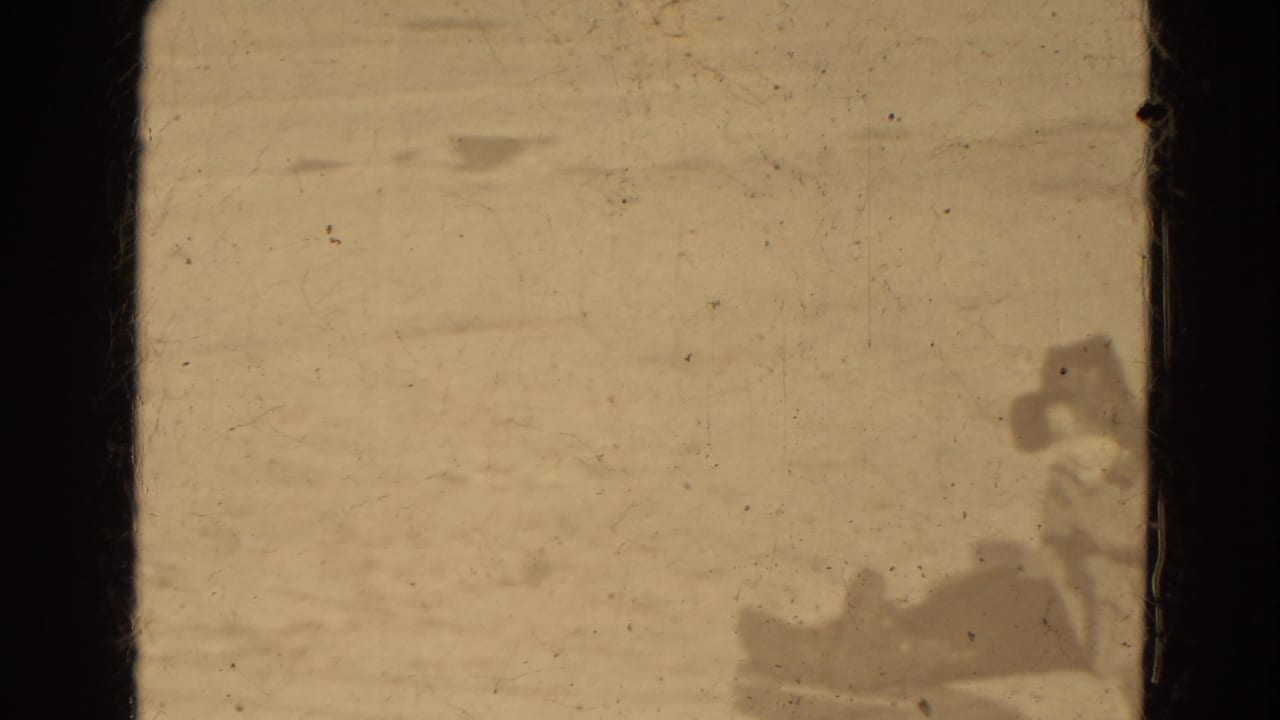 A sled and bundled figures appear near the right edge of a snowy frame.