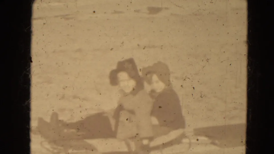 Closer soft-focus frame of two bundled young people beside or on a sled in snowy Lincoln, Nebraska.
