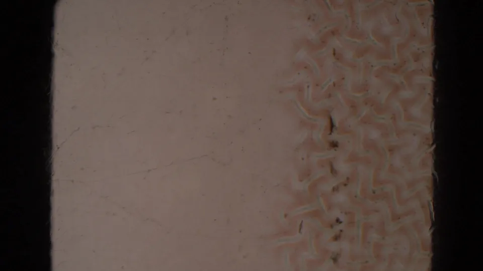 Blank 8mm frame from the supplied Lincoln, Nebraska home-movie metadata, showing pale film stock, grain, scratches, dust, and dark frame edges.