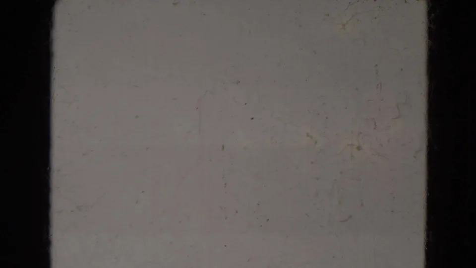 Blank 8mm home-movie frame, supported by metadata as Lincoln, Nebraska, showing muted film stock, scuffs, dust, and static exposure.
