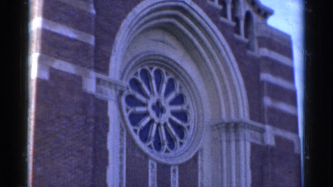 1975 Bridgeport church exterior with a circular rose window centered inside layered arched stonework on a brick facade.