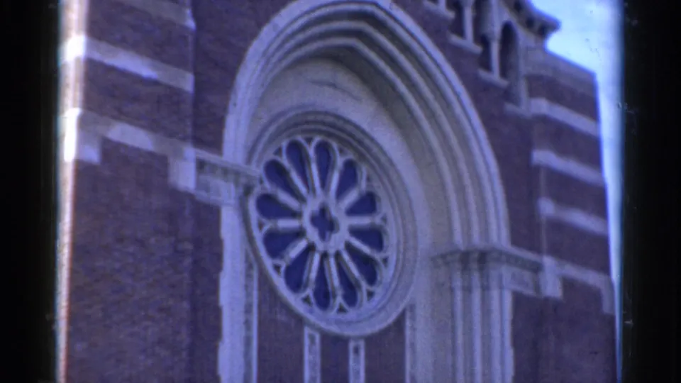 1975 Bridgeport church exterior with a circular rose window centered inside layered arched stonework on a brick facade.