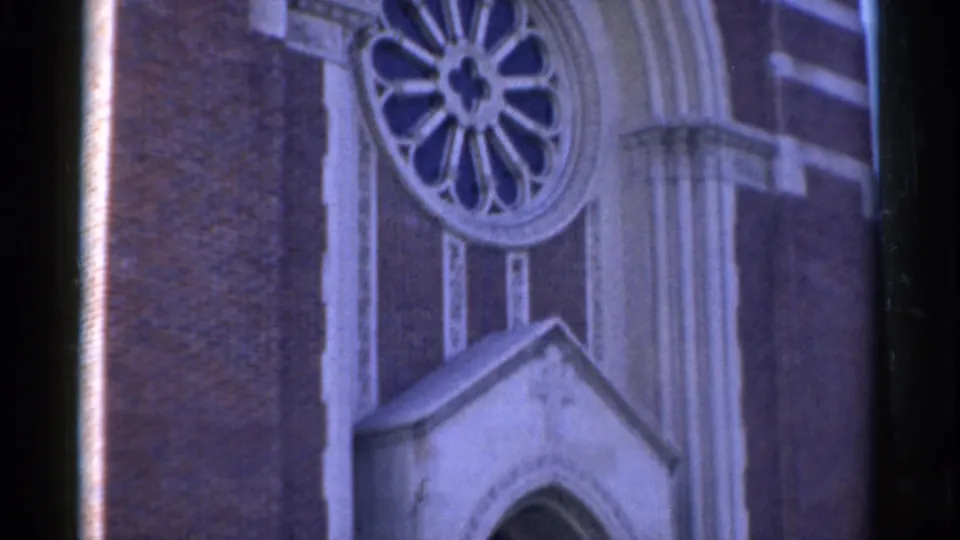 1975 Bridgeport 8mm frame showing the church rose window above a small peaked entry canopy and arched doorway detail.