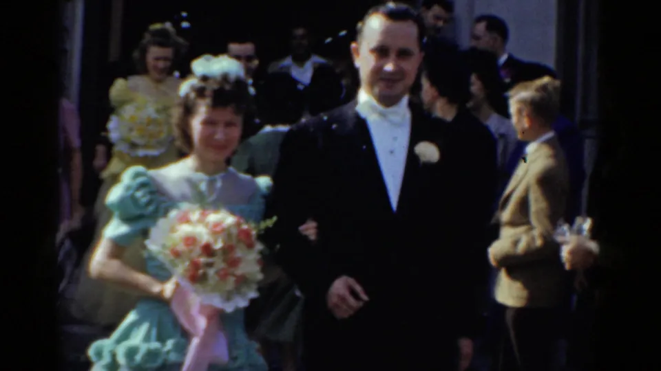 Another formally dressed wedding couple appears outside the church, the bride in a pale blue dress holding a flower bouquet.