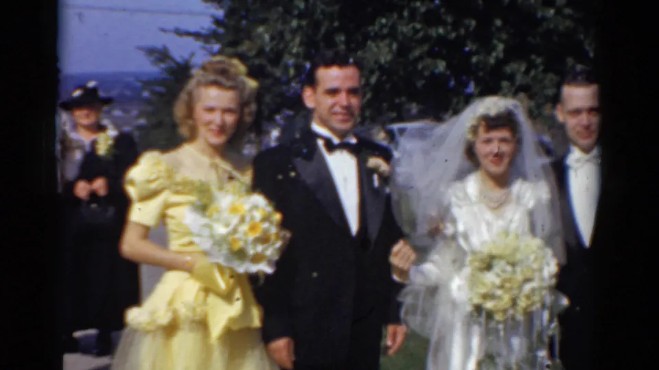 1975 Bridgeport wedding party poses on a lawn, with bride, groom, bridesmaid in yellow, tuxedoed man, bouquets, and trees visible.