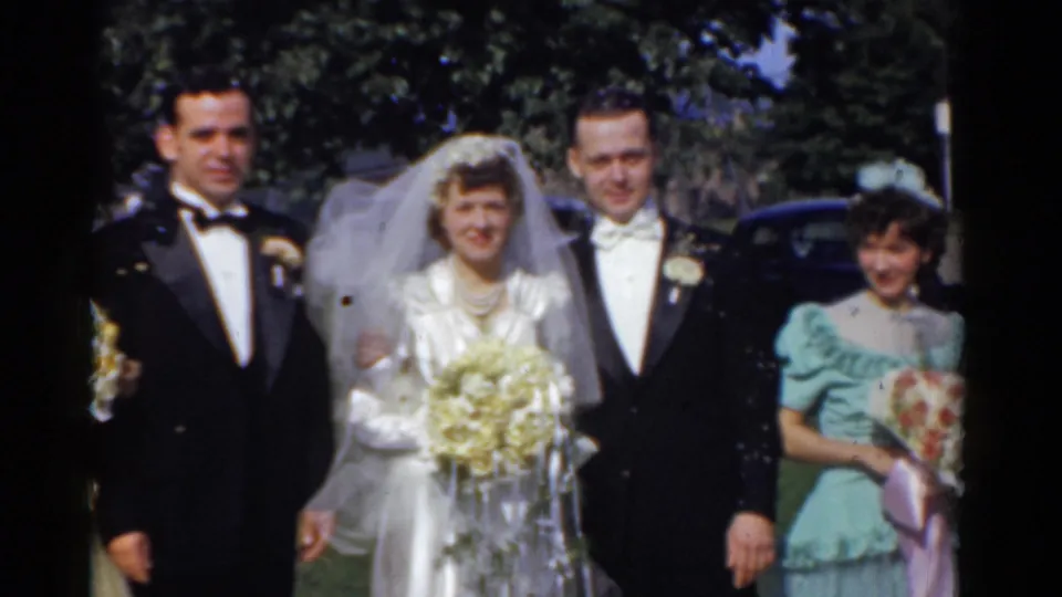 1975 Bridgeport wedding party outdoors with bride in veil, groom and attendant in tuxedos, and bridesmaid in mint green dress holding a bouquet.