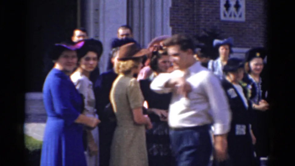1975 Bridgeport wedding guests gathered near a building entrance, including women in formal dresses and hats and a man in a white shirt.
