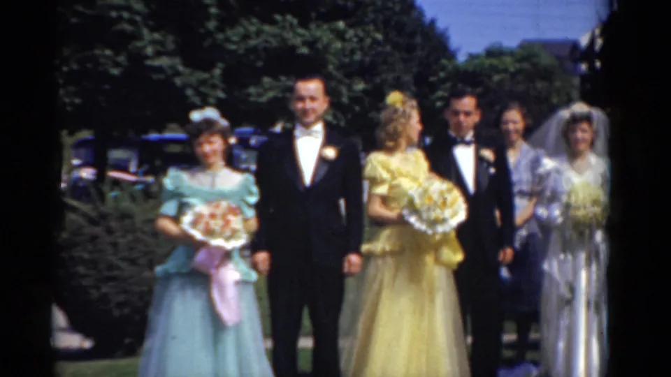 Bridgeport 1975 outdoor wedding group, showing bridesmaids in pastel dresses, tuxedoed men, and a veiled bride in the background.