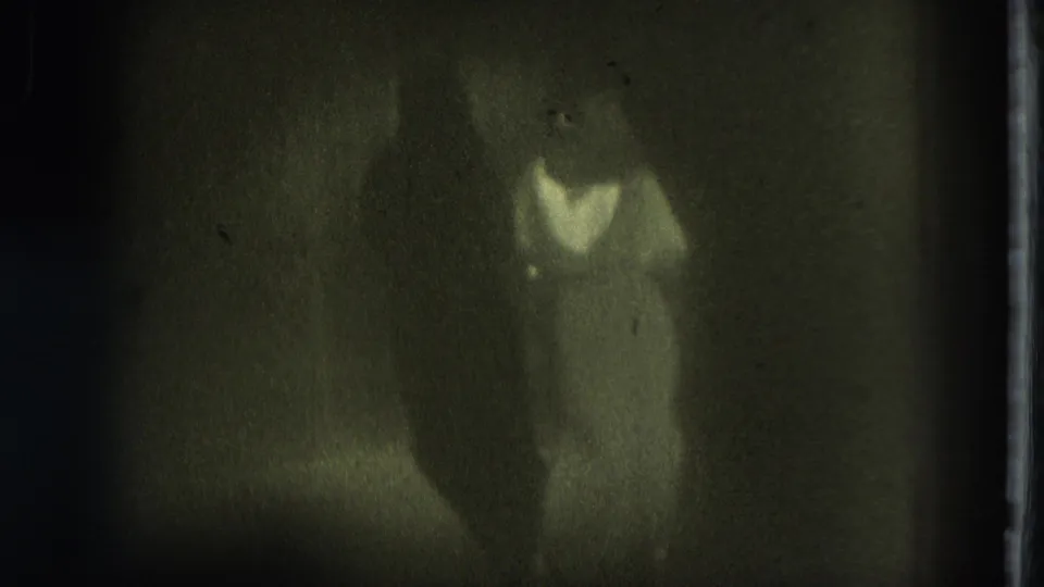 1975 San Francisco frame with a dancer in a light dress partly silhouetted against a dark stage background.