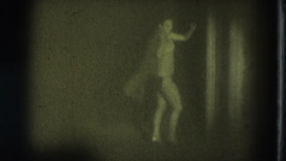 The performer is seen in profile-like motion near the stage edge, faintly visible against a dark backdrop in the 1975 San Francisco clip.