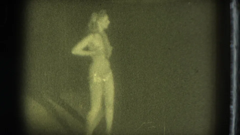 1975 San Francisco 8mm frame of an adult woman in profile, softly focused against a dark interior-like background.