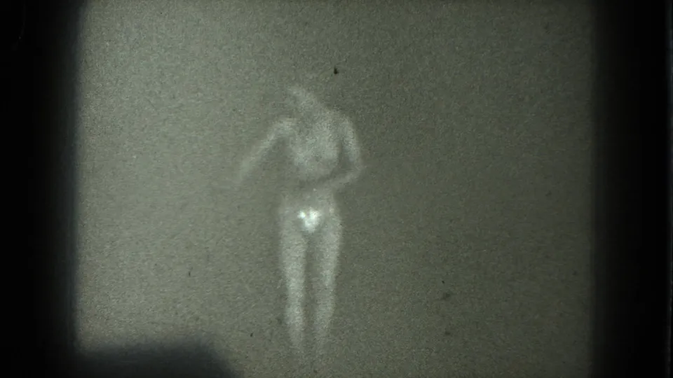1975 San Francisco 8mm frame showing a nude adult woman in heels bending forward during a private dance performance.