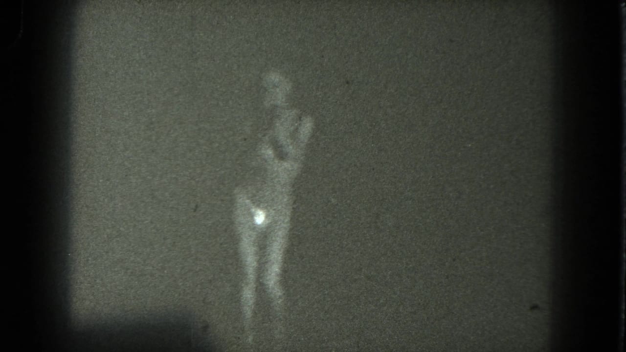 1975 8mm San Francisco footage appears to show a blurred minimally clothed dancer facing the camera in a dim room.
