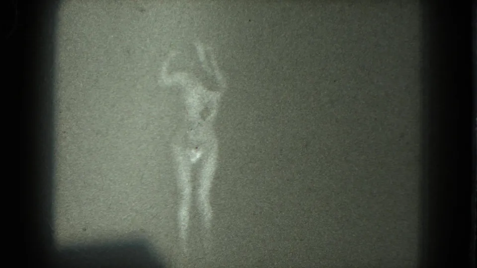 A closer 8mm view shows the dancer’s upper body and legs in soft focus, with the room and face remaining indistinct.