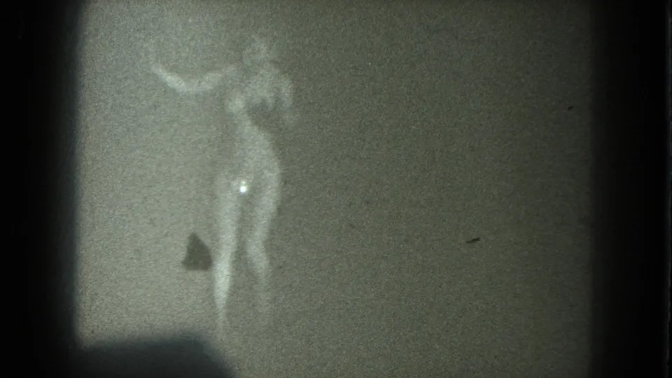 A nude adult figure appears mid-movement in grainy 8mm footage, with the 1975 San Francisco setting supported by clip metadata.
