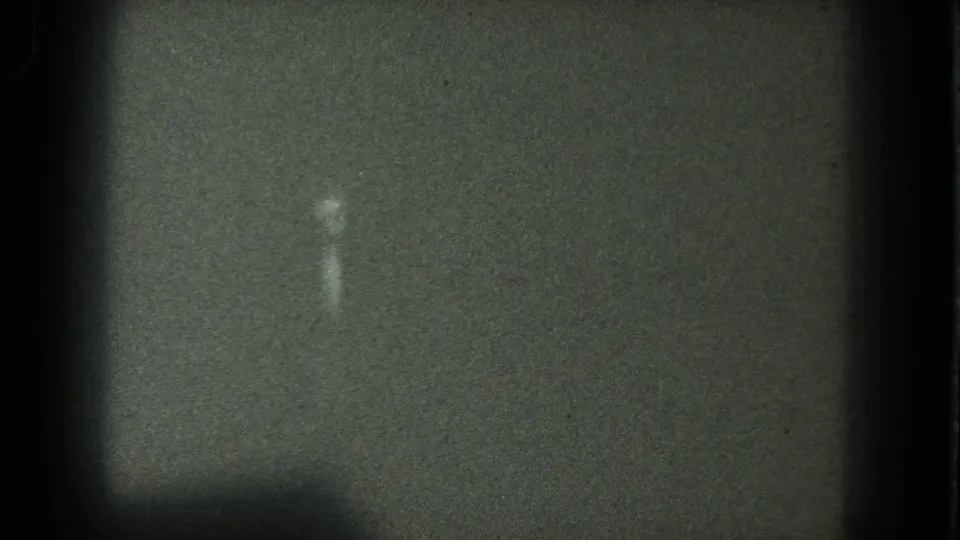 Very faint figure in a dark 8mm frame, with San Francisco and 1975 supported by clip metadata rather than visible landmarks.