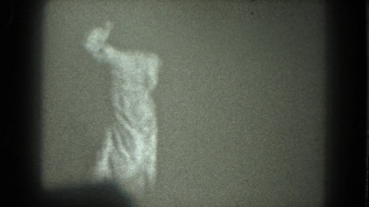Adult woman in a light robe appears to dance indoors in grainy 1975 8mm home-movie footage from San Francisco metadata.
