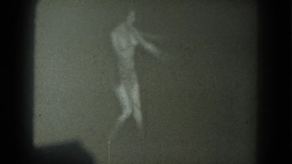 1975 8mm San Francisco footage of a female dancer twisting with an arm extended, seen through soft grain and low contrast.