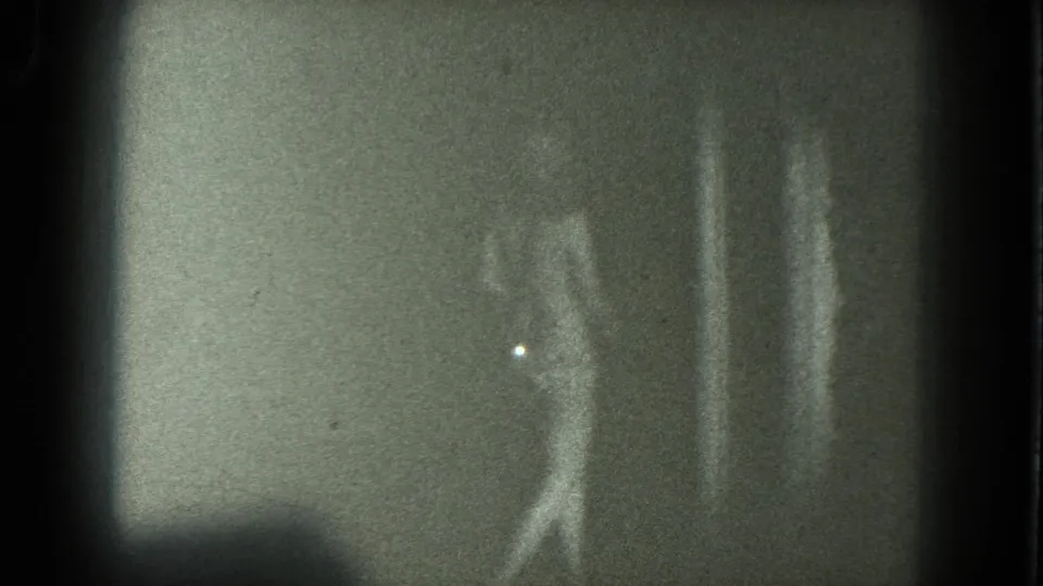 1975 San Francisco 8mm frame of the woman continuing to dance in soft focus beside a brighter patch of wall or light.