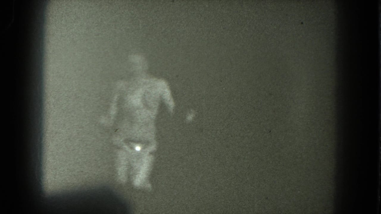 1975 San Francisco 8mm frame showing a nude adult woman dancing in soft focus, with a glittering belt catching light at her waist.
