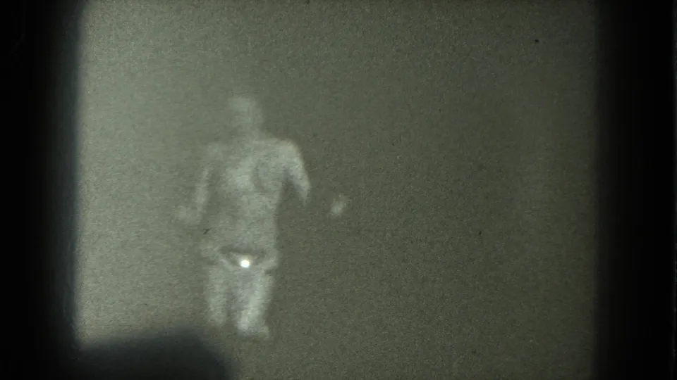 1975 San Francisco 8mm frame showing a nude adult woman dancing in soft focus, with a glittering belt catching light at her waist.