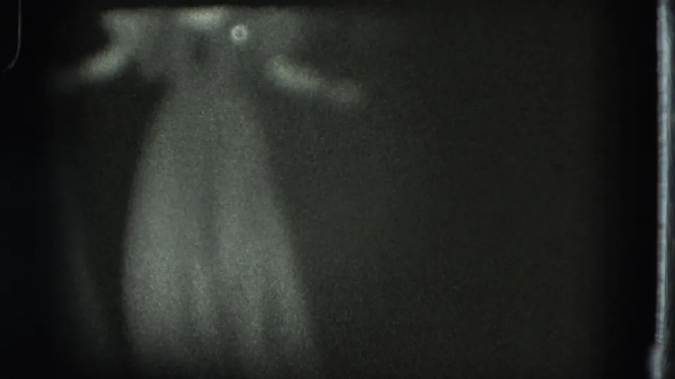 Final dark 1975 San Francisco 8mm frame with the performer’s pale dress and outstretched arms most visible.