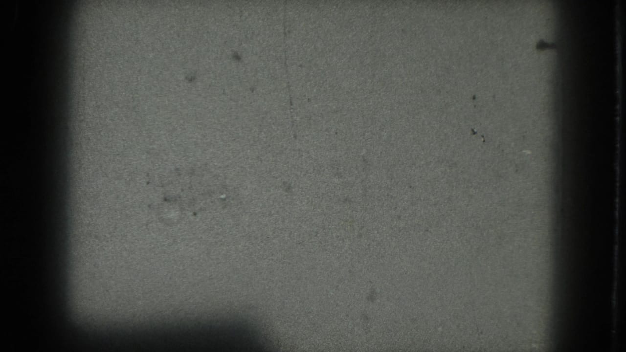 A faint female performer appears as a pale blurred shape in a dark 1975 San Francisco 8mm frame.