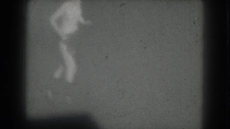 A blurred female gogo dancer silhouette poses with an arm raised in the 1975 San Francisco 8mm home-movie frame.