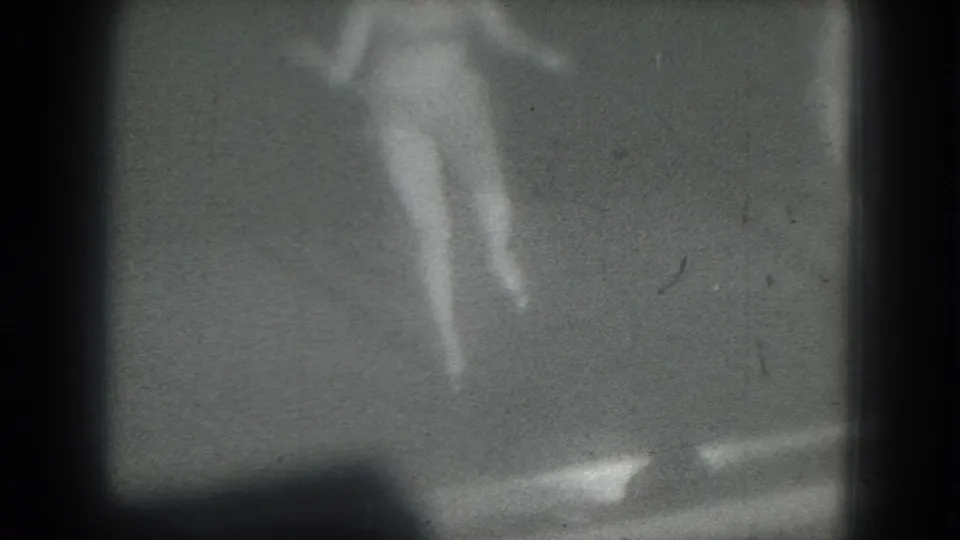 A grainy 1975 San Francisco 8mm frame shows the dancer mid-step, with stage details mostly indistinct.