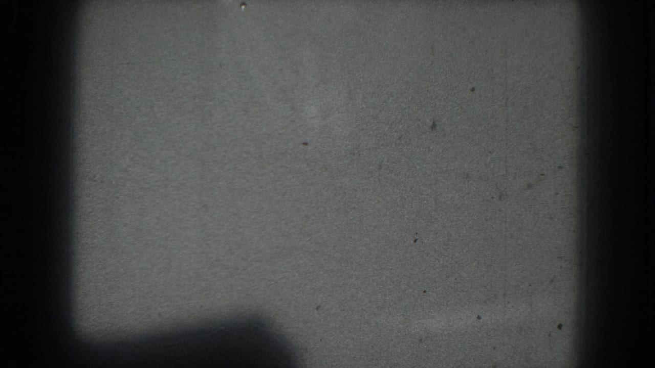 Mostly empty gray field with dark vertical obstruction and low shadow near the bottom.