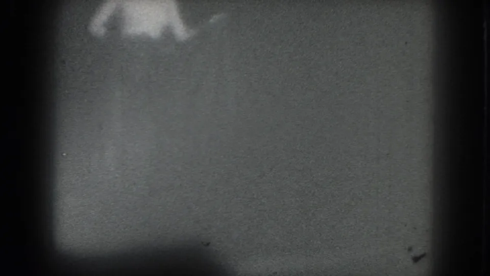 Indistinct 1975 San Francisco stage-performance frame with a pale figure partly lost in blur and grain.