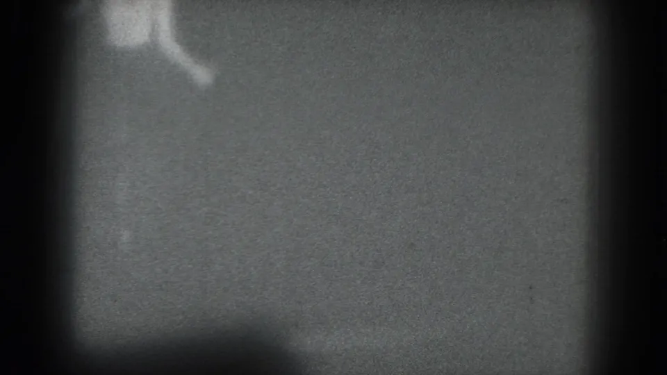 1975 San Francisco 8mm frame showing a barely legible performer fragment near the upper left of the stage area.