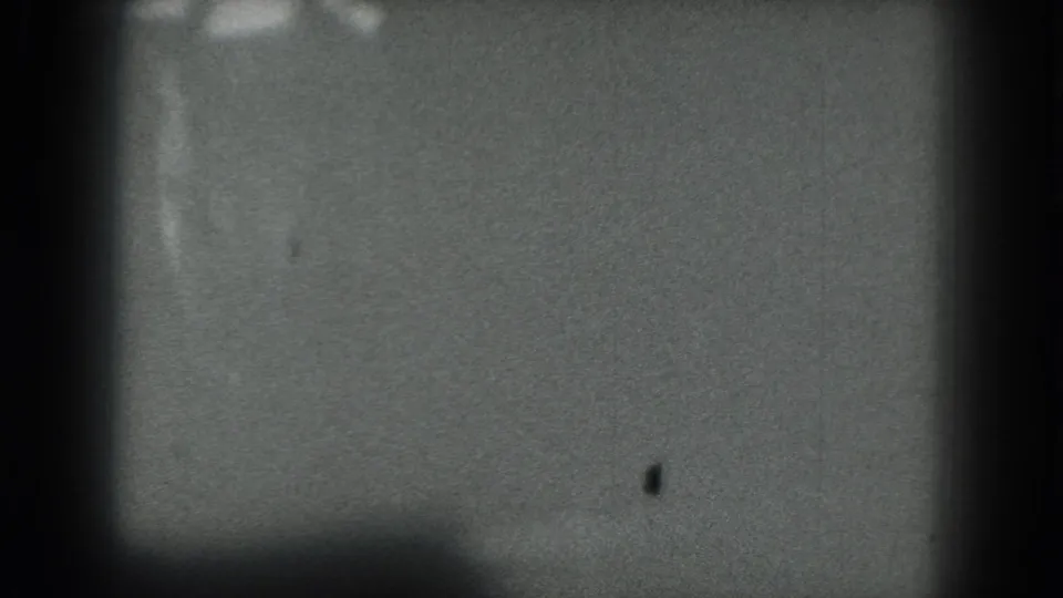 Closing 1975 San Francisco 8mm frame with the stage area largely empty and the performer barely visible near the top.