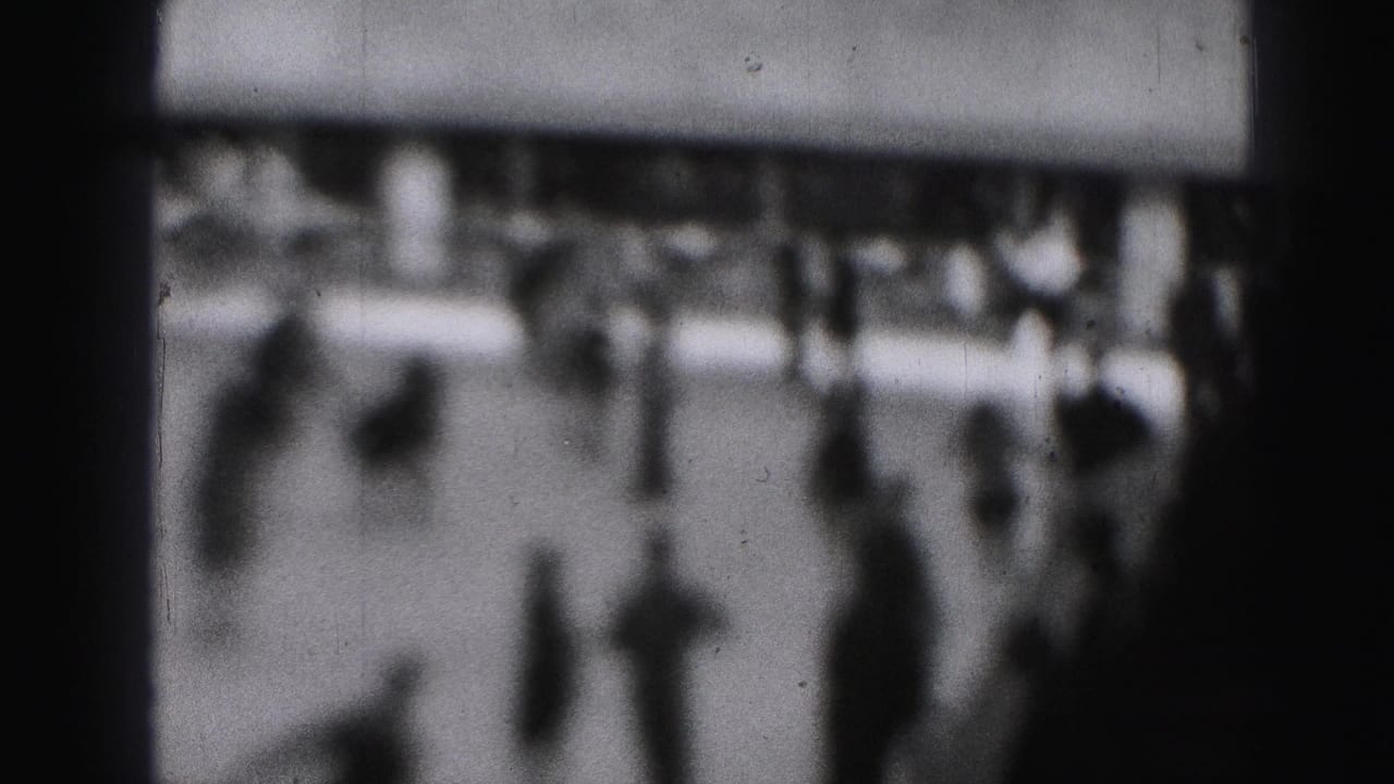 Blurred skaters and spectators near the edge of an ice rink.