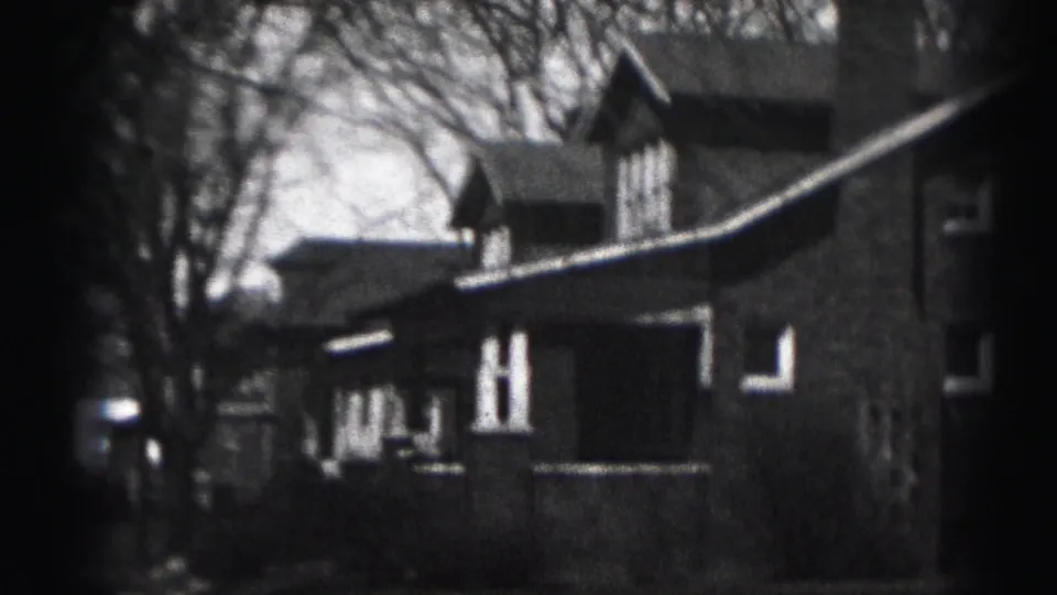 Harrisburg 1975 8mm view of a brick residential building framed by bare trees and soft film edges.