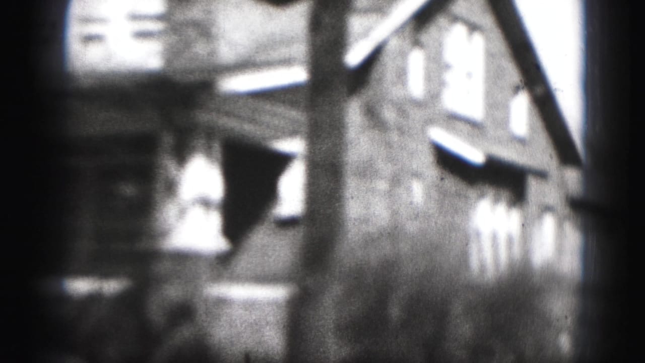 Soft-focus 1975 8mm view in Harrisburg, Pennsylvania, showing residential buildings or row houses seen from a moving handheld camera.