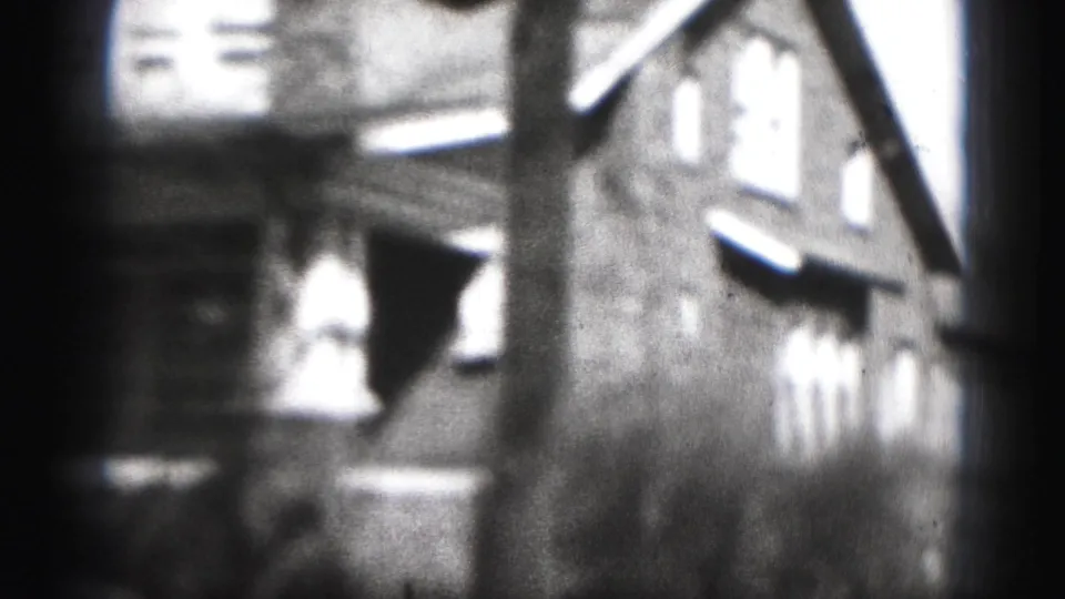 Soft-focus 1975 8mm view in Harrisburg, Pennsylvania, showing residential buildings or row houses seen from a moving handheld camera.