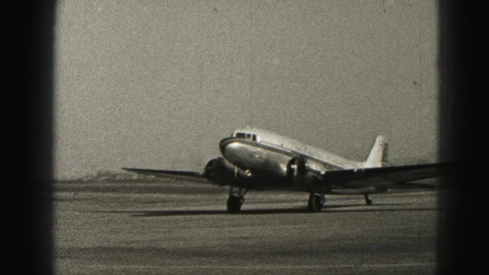 Side view of a small passenger aircraft taxiing at Harrisburg, Pennsylvania, in 1975 archival 8mm footage.