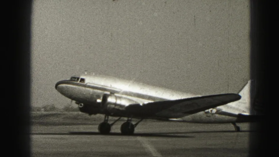 A small propeller passenger aircraft taxis at Harrisburg in 1975, with wing and landing gear prominent in frame.