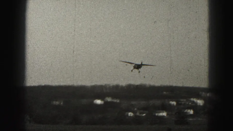 A closer frame shows the small aircraft with landing gear down over distant Harrisburg suburban houses.