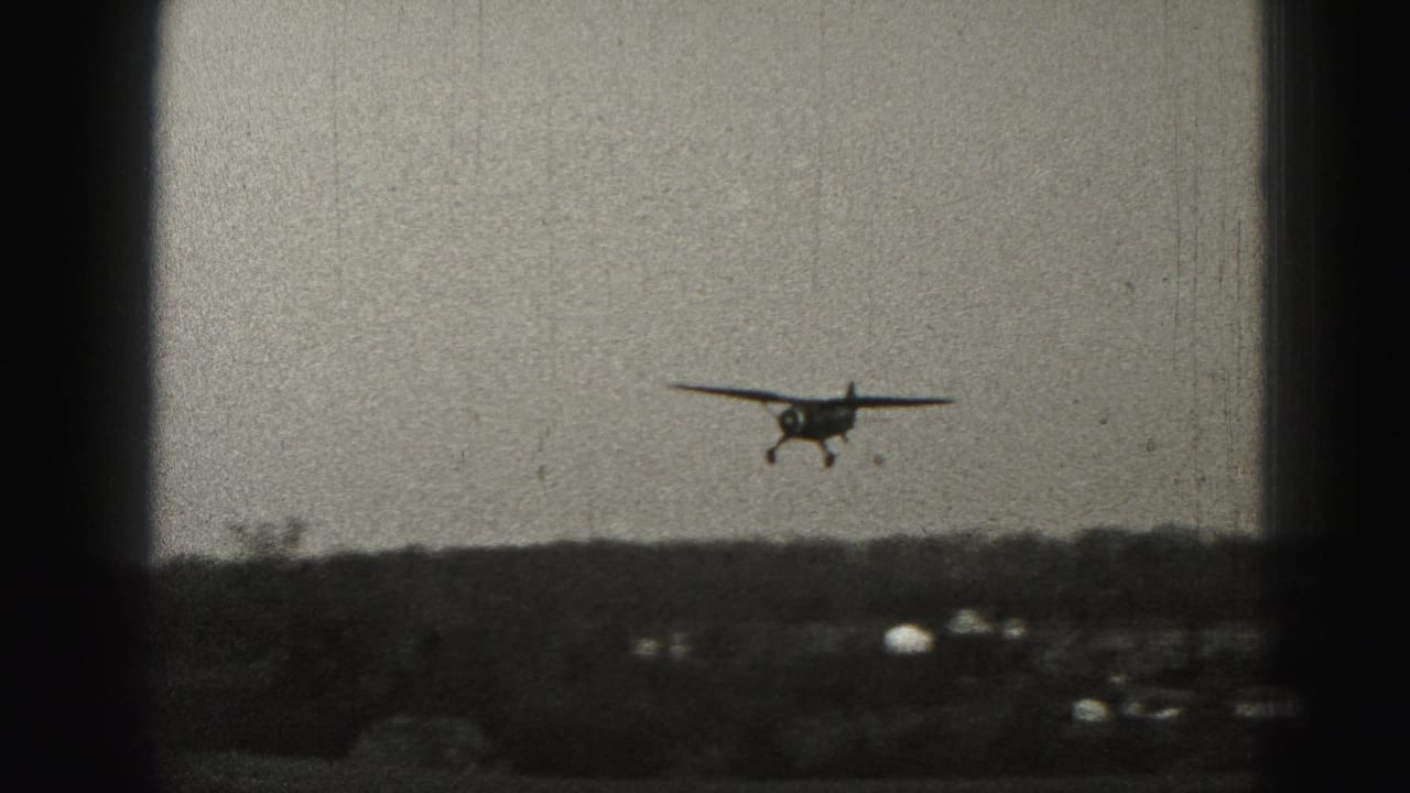 A small propeller airplane appears in the distance over a low Harrisburg-area landscape in 1975 8mm home-movie footage.