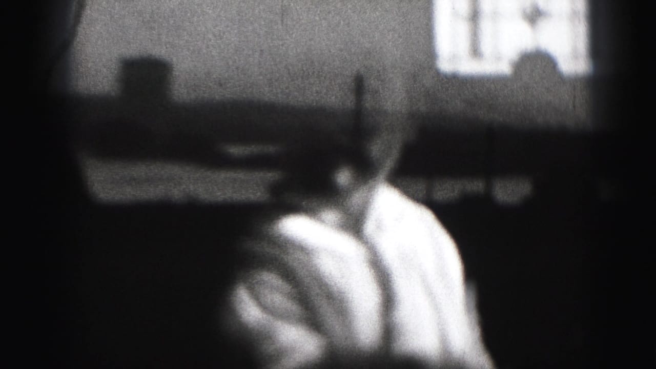 Baby turned slightly to the side in a grainy dark room with a bright background shape.