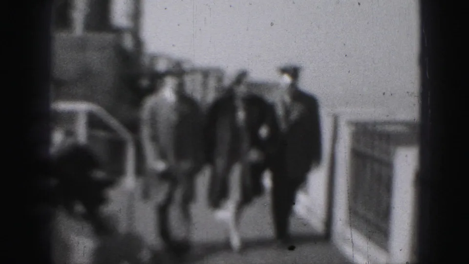 In 1975 Harrisburg-associated home-movie footage, three adults appear on a ship deck, with two men in hats near a woman as they approach the camera.