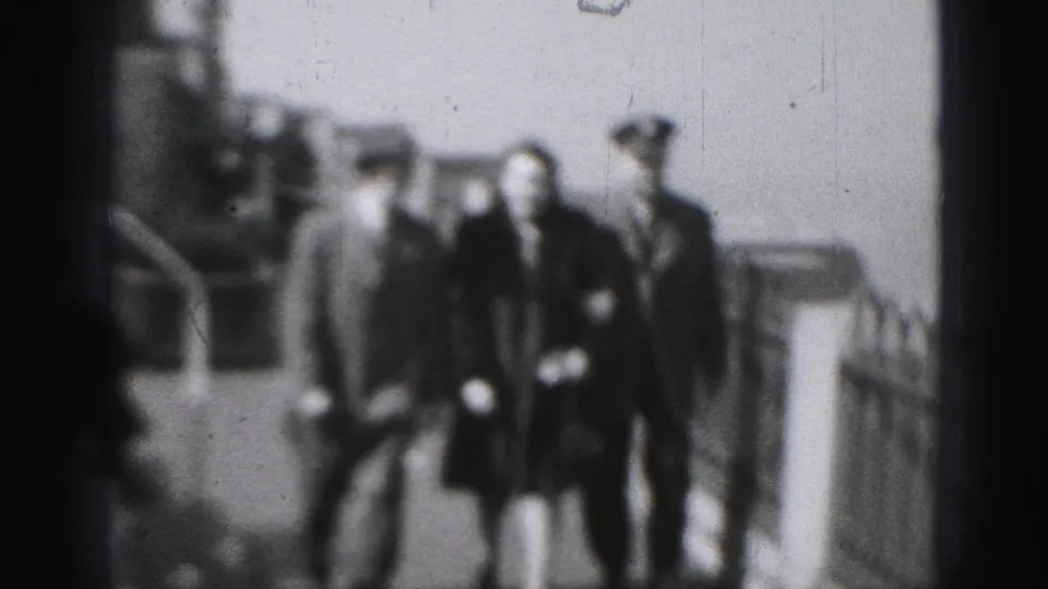 The trio approaches on the deck, with the woman centered between two hat-wearing men and ship railings visible in the background.