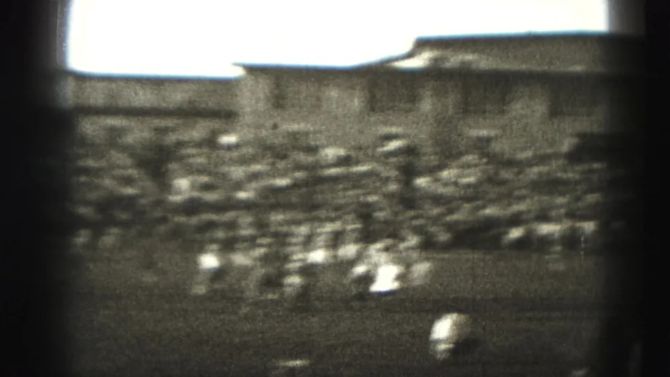 The home-movie camera pans quickly during the Harrisburg football game, leaving players and spectators motion-blurred across the frame.