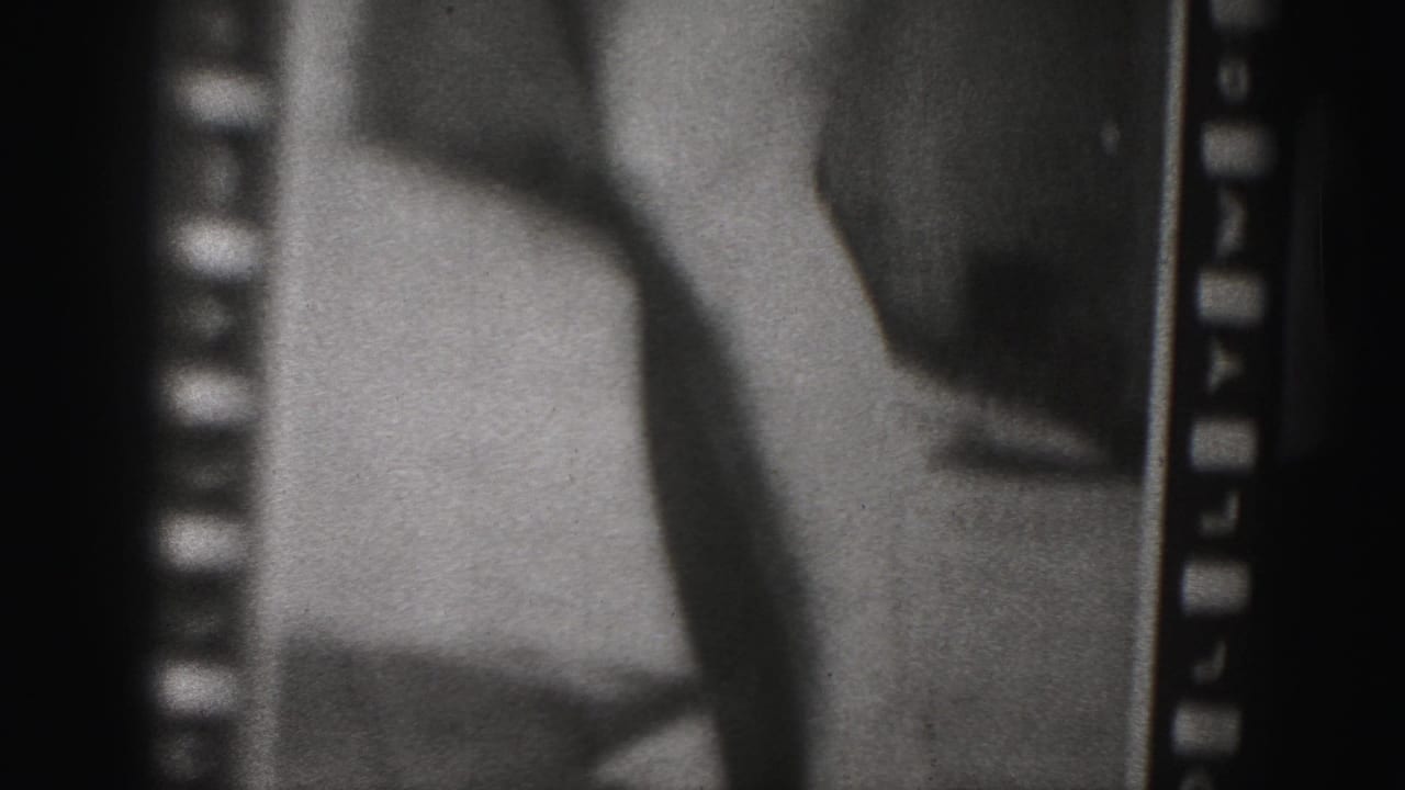 1975 Harrisburg-area 8mm frame showing a close cropped view of a woman in swimwear, with legs, lower torso, grain, and sprocket-edge framing visible.