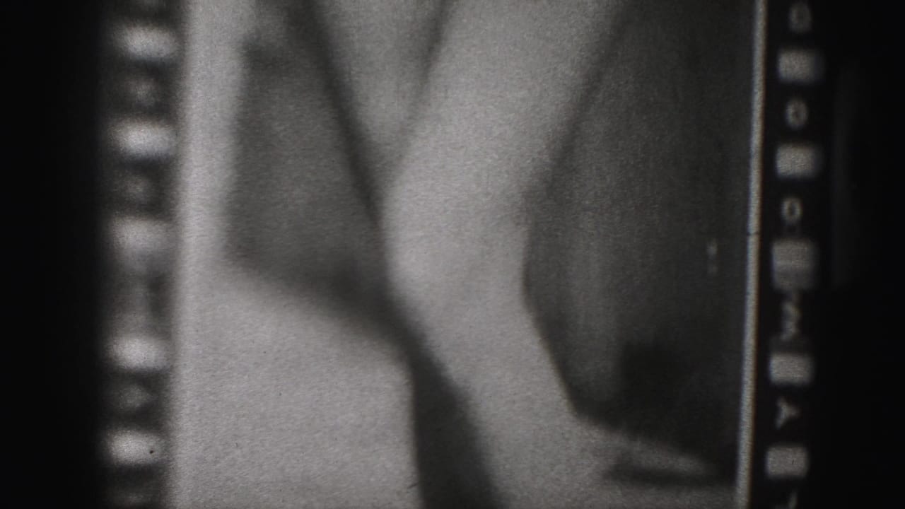1975 Harrisburg-area home-movie frame with a close view of a woman's torso and arm in swimwear, bordered by visible 8mm sprocket holes.